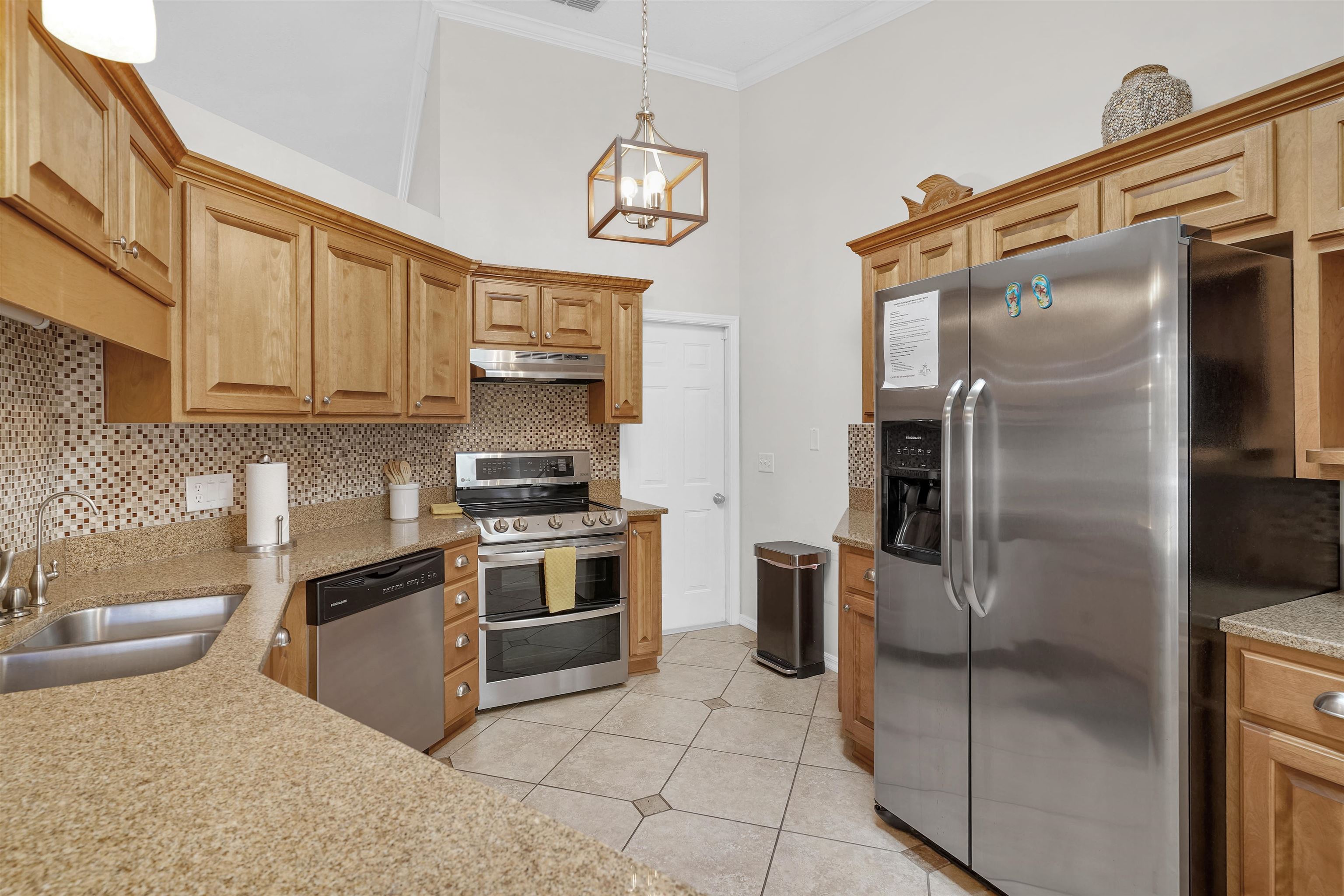 404 Fourteenth Street St. Augustine, FL 32084 - Photo 11 of 35 a kitchen with stainless steel appliances granite countertop a refrigerator a stove and a sink with wooden floor