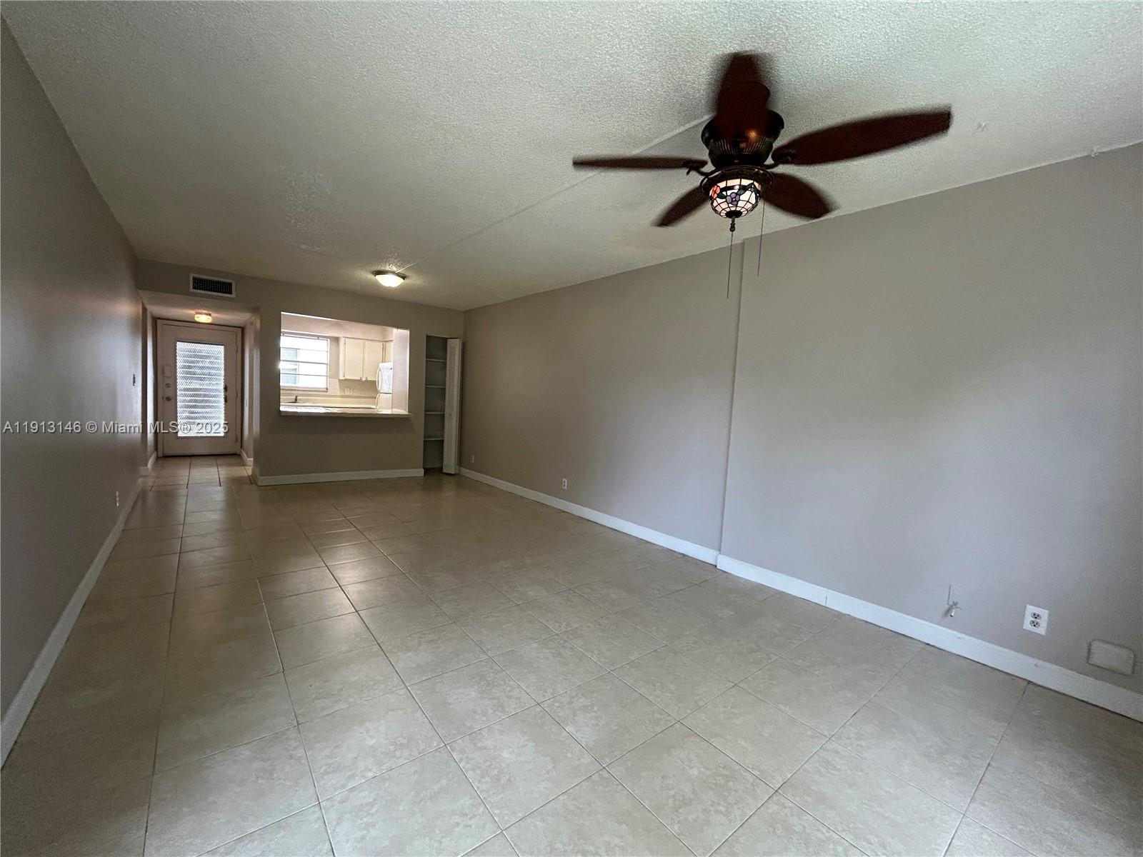 6505 Winfield Boulevard, Unit B18 Margate, FL 33063 - Photo 3 of 15 an empty room with windows and ceiling fan