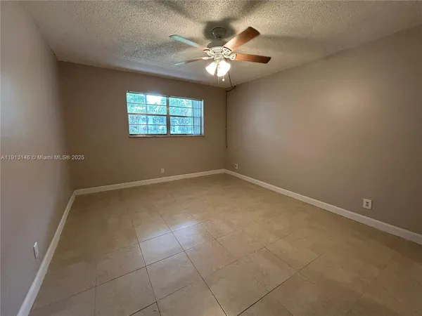 en empty room with windows and ceiling fan