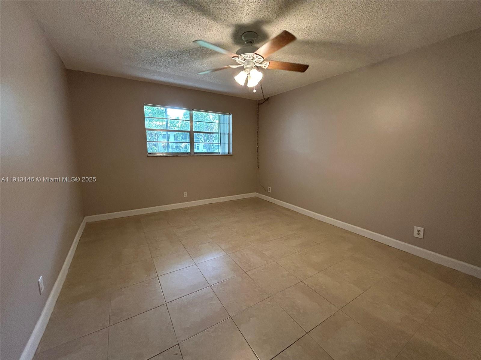 6505 Winfield Boulevard, Unit B18 Margate, FL 33063 - Photo 5 of 15 en empty room with windows and ceiling fan