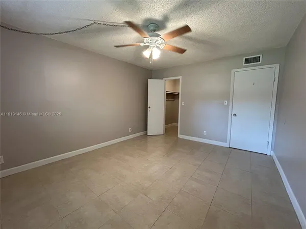 an empty room with closet and ceiling fan