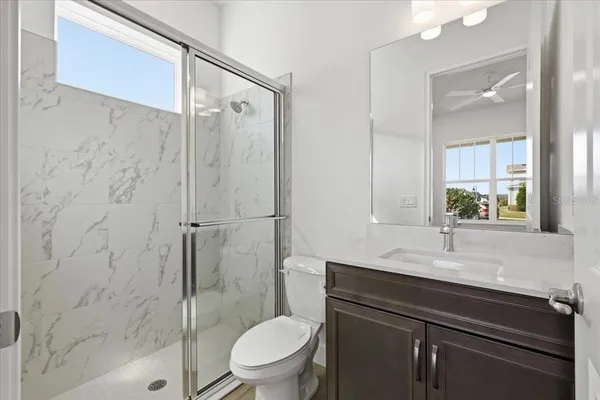 a bathroom with a sink a toilet and shower