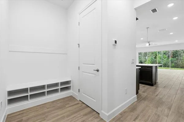 a view of empty room with wooden floor and fan