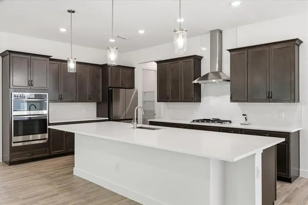 a kitchen with stainless steel appliances a refrigerator a stove a sink and a center island