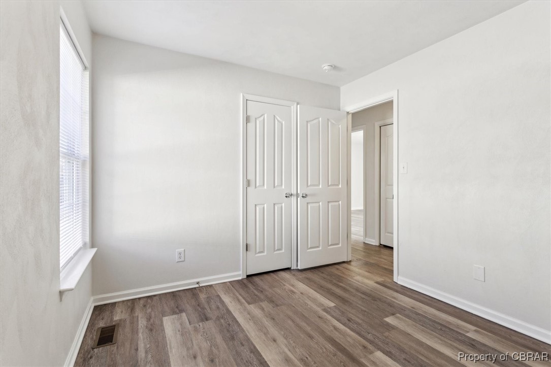 111 Pleasant Spring Avenue Waverly, VA 23890 - Photo 18 of 32 Unfurnished bedroom featuring a closet, hardwood / wood-style floors, and multiple windows