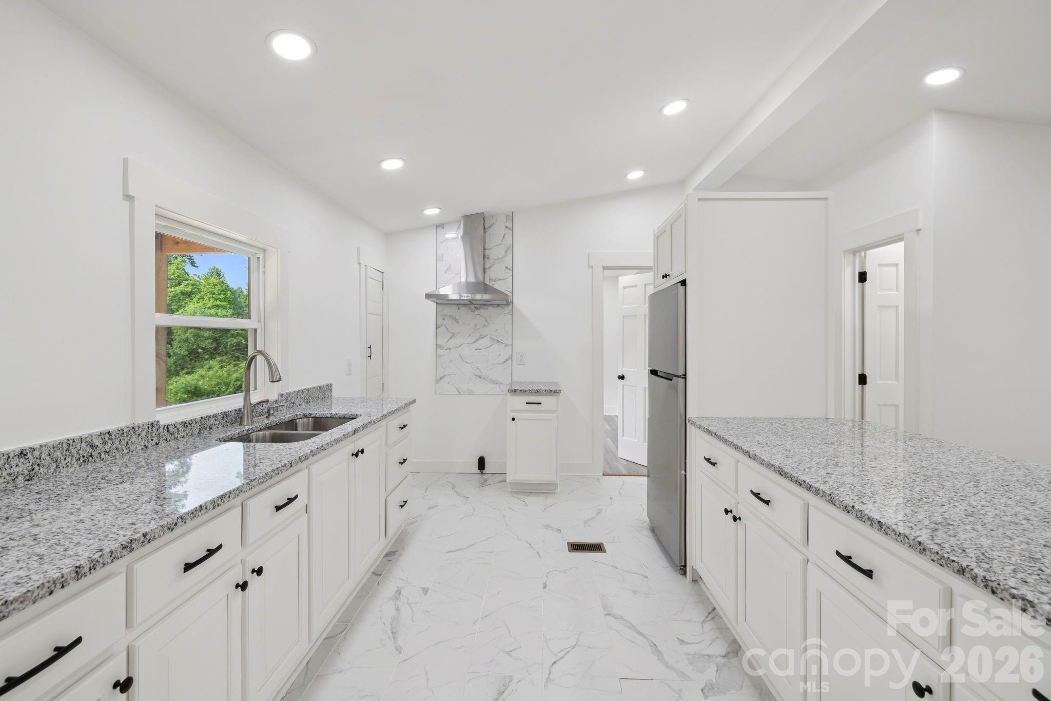 431 Pole Miller Extension Brevard, NC 28712 - Photo 2 of 24 a large white bathroom with a granite countertop sink a toilet a large mirror and shower