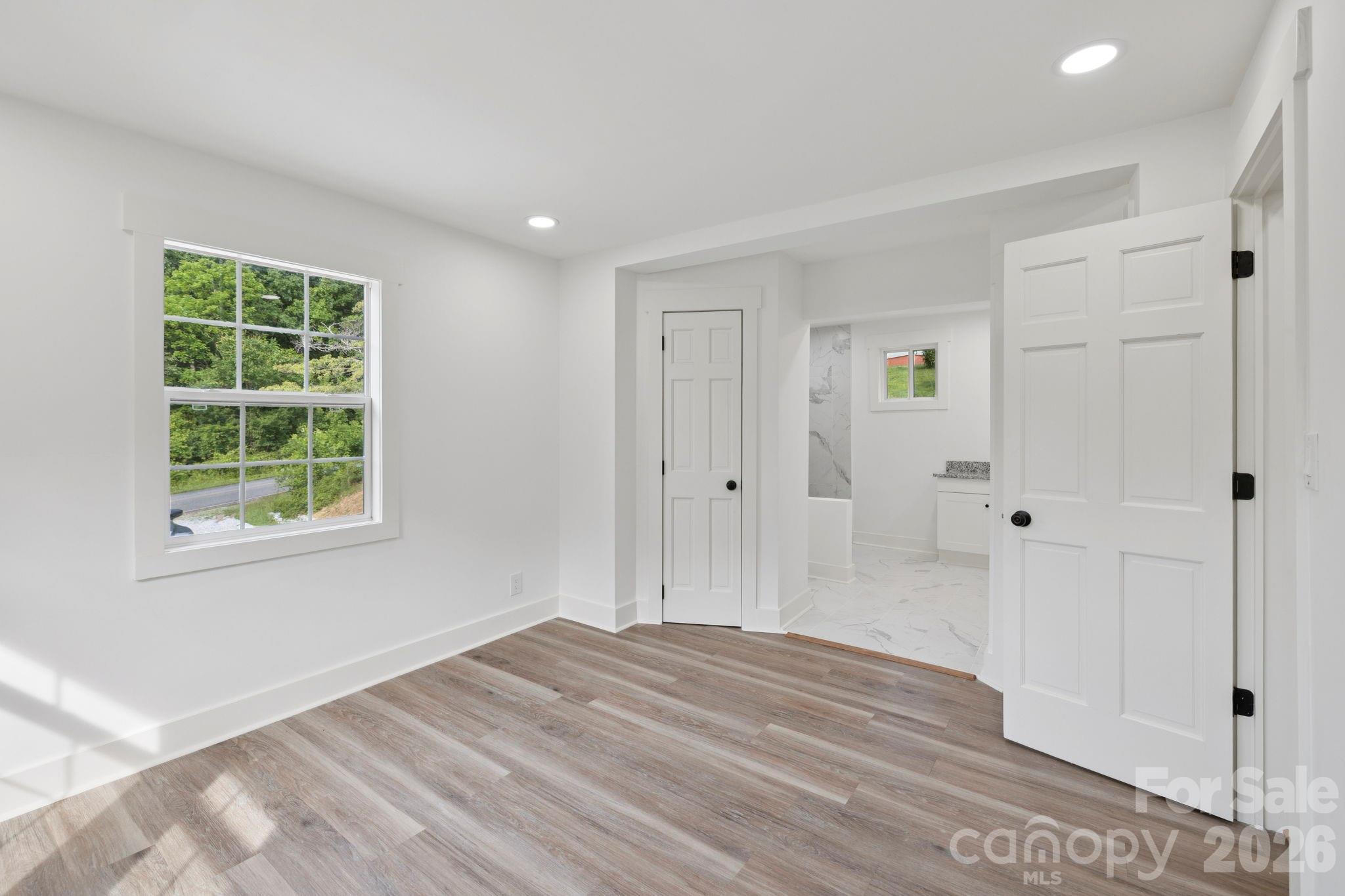 431 Pole Miller Extension Brevard, NC 28712 - Photo 10 of 24 a view of a bedroom with wooden floor and windows