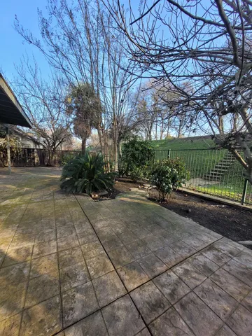 a view of a street with a bench and trees