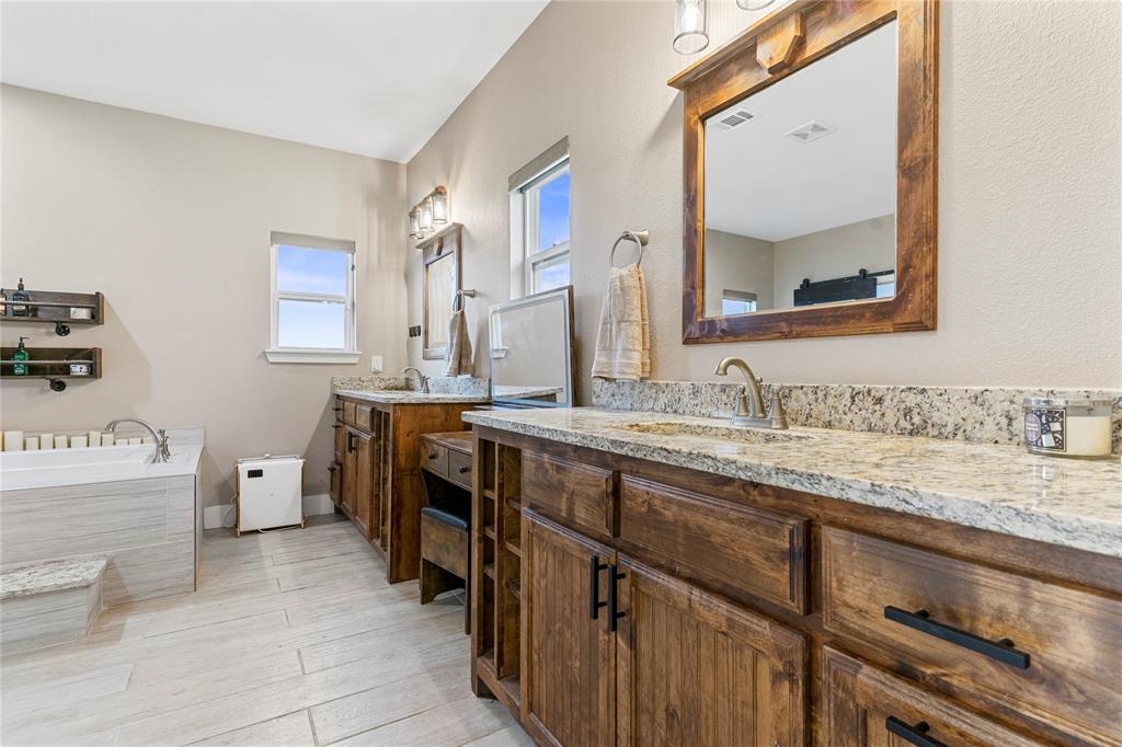 139 Kriston Lane Springtown, TX 76082 - Photo 23 of 39 Dual wood vanities with granite countertops, undermount sinks, and matte black hardware
