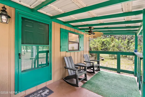 a view of a porch with furniture and a backyard