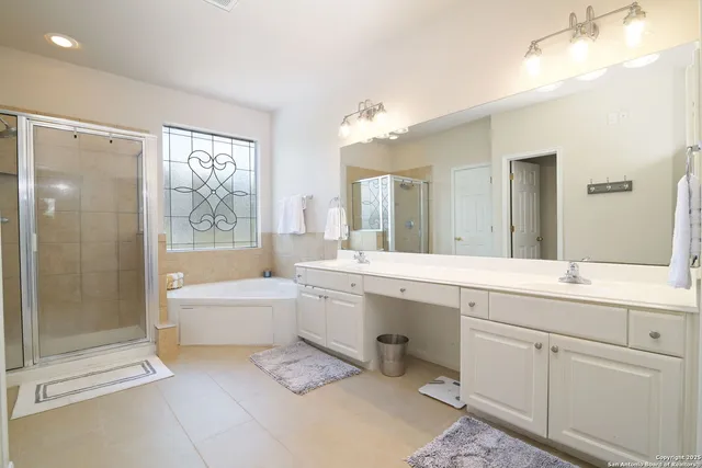 a spacious bathroom with a bathtub shower sink mirror and toilet