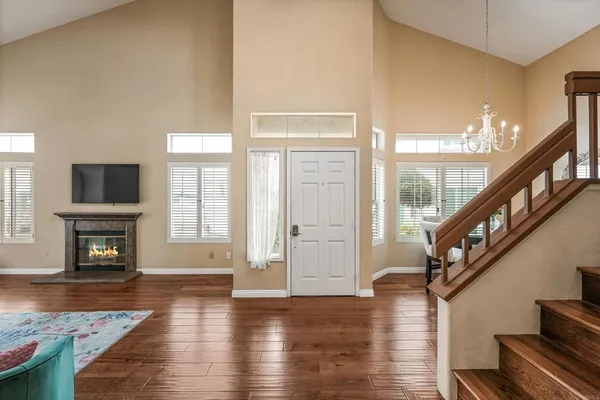 a view of an entryway with wooden floor and a fireplace