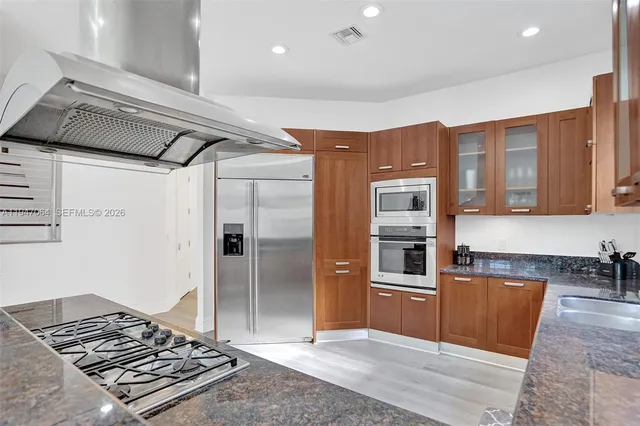 a kitchen with stainless steel appliances granite countertop a refrigerator and a sink
