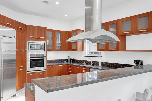 a kitchen with stainless steel appliances granite countertop a sink a stove and a microwave oven
