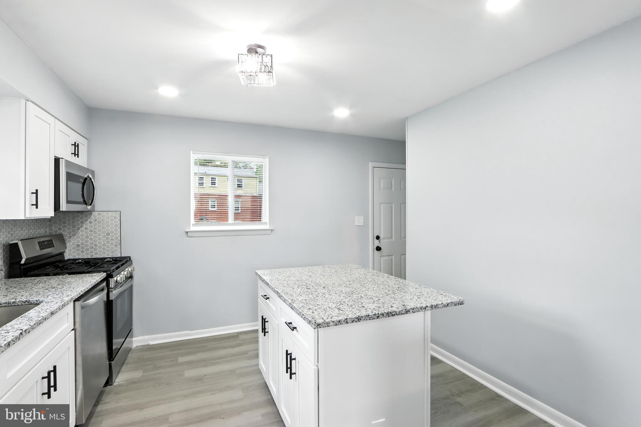 6603 Fairmount Avenue Baltimore, MD 21215 - Photo 3 of 19 a kitchen that has a sink and a stove in it