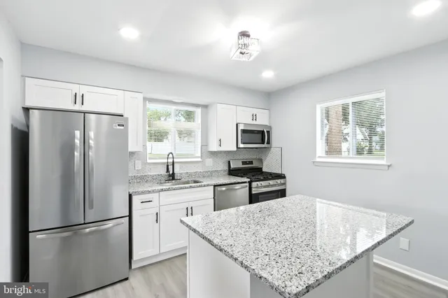 a kitchen with stainless steel appliances granite countertop refrigerator sink and cabinets