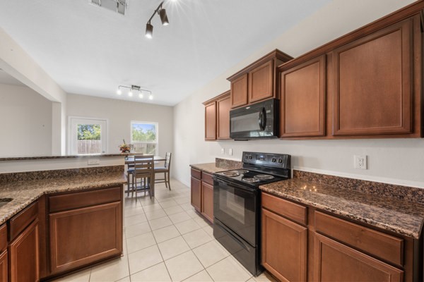 1327 Diamond Drape Drive Rosharon, TX 77583 - Photo 7 of 26 a kitchen with granite countertop a stove top oven microwave and cabinets