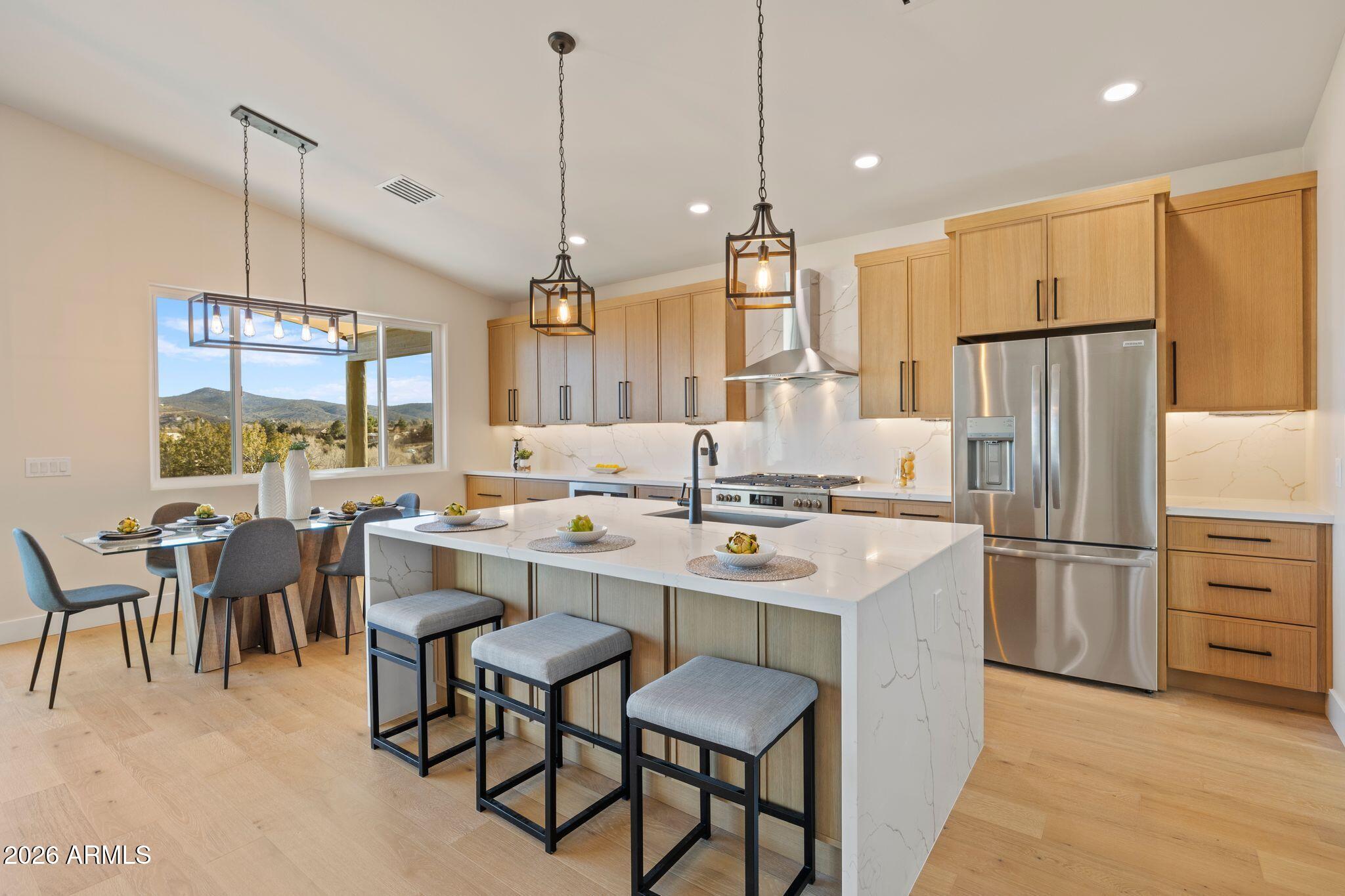 4535 Victor Drive Prescott, AZ 86301 - Photo 12 of 43 a kitchen with kitchen island a refrigerator a stove a dining table and chairs