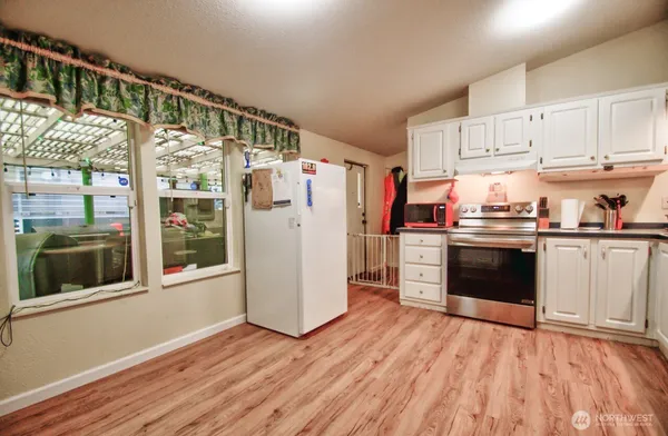 a kitchen with granite countertop a refrigerator and a stove top oven