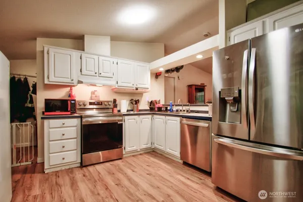 a kitchen with stainless steel appliances a refrigerator stove and microwave