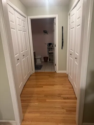 a view of a hallway with wooden floor and staircase