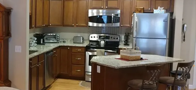 a kitchen with stainless steel appliances granite countertop a refrigerator a stove and a cabinets