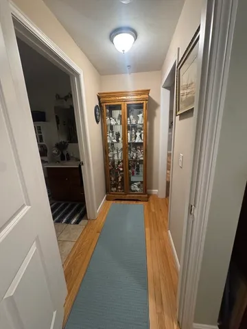 a view of a hallway with wooden floor and stairs