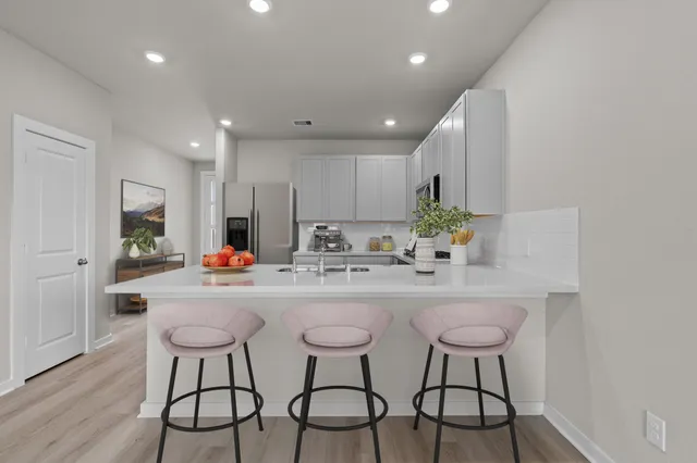 a kitchen with refrigerator and chairs