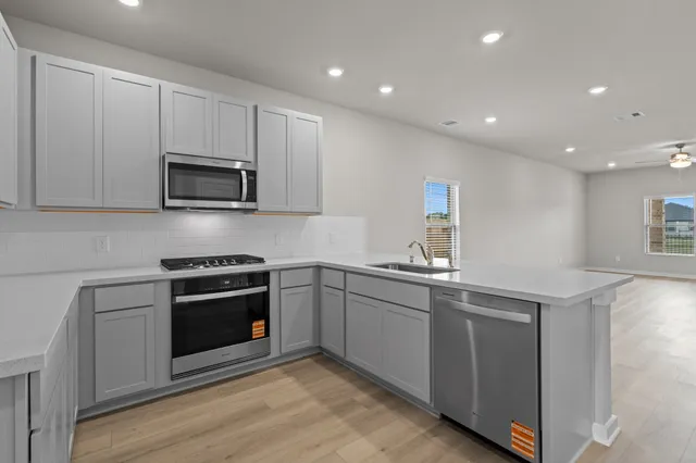 a kitchen with granite countertop a sink and steel appliances