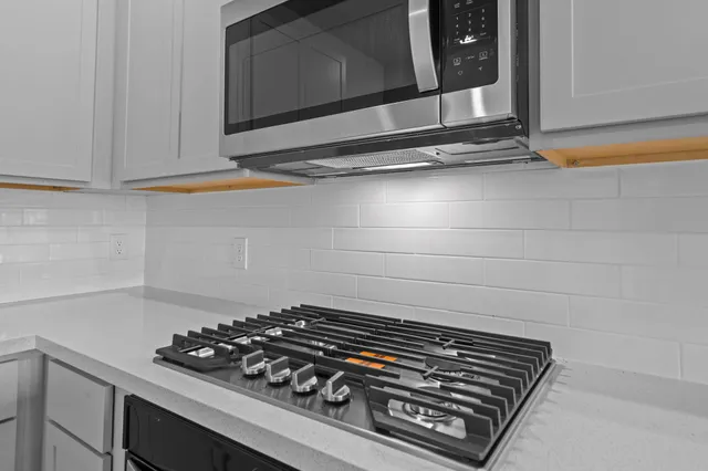a stove top oven sitting inside of a kitchen