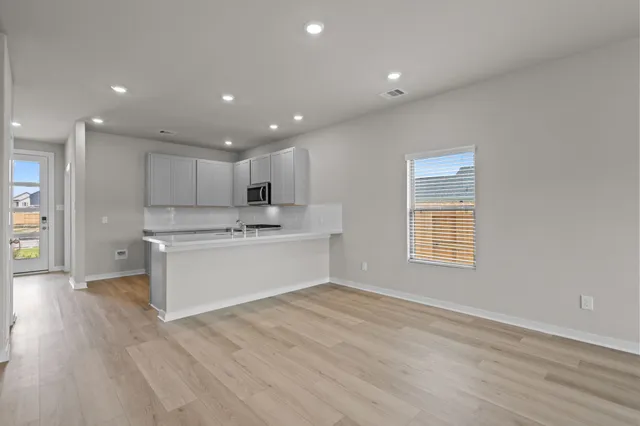 a view of a kitchen with wooden floor and electronic appliances