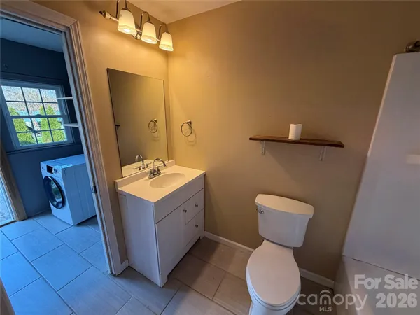 a bathroom with a sink mirror vanity and toilet