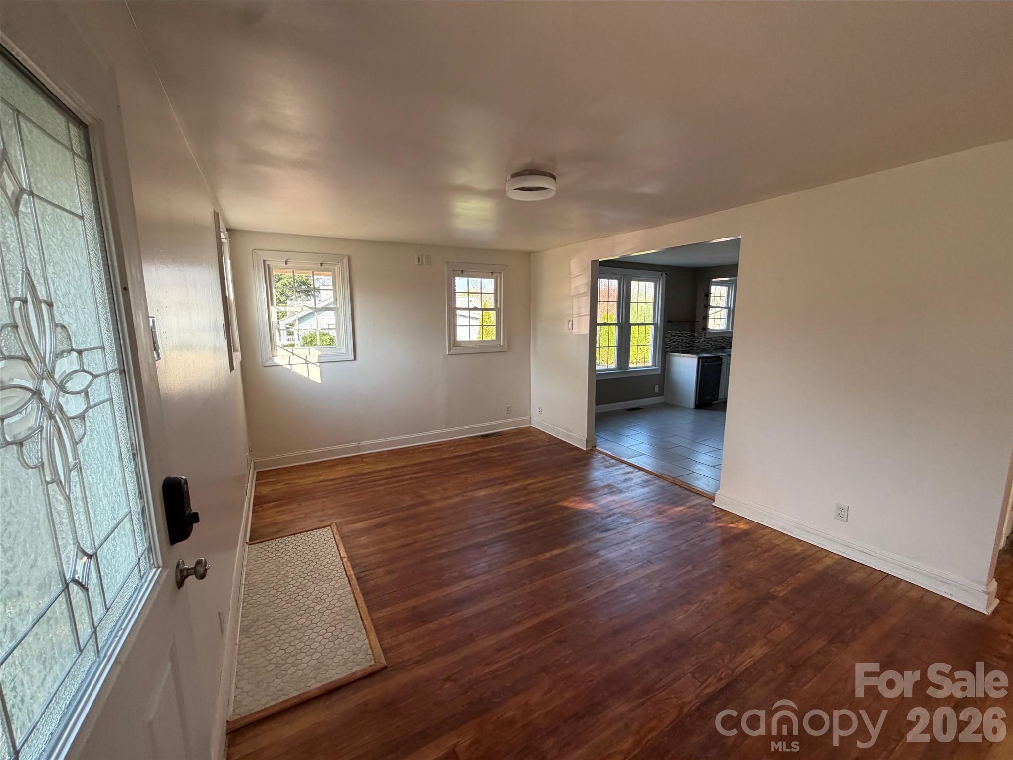405 Jug Wilson Street Morganton, NC 28655 - Photo 2 of 21 an empty room with wooden floor and windows