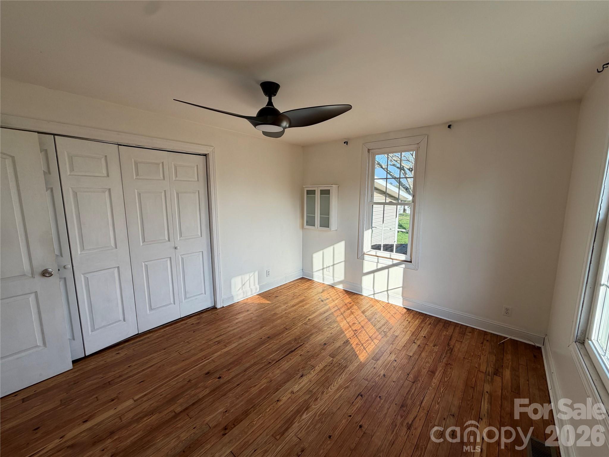 405 Jug Wilson Street Morganton, NC 28655 - Photo 9 of 21 a view of empty room with wooden floor and fan