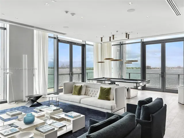 a living room with furniture and large windows