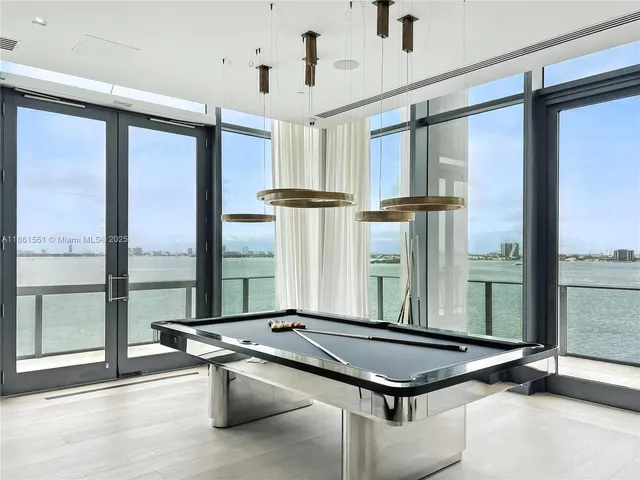a room with pool table and windows