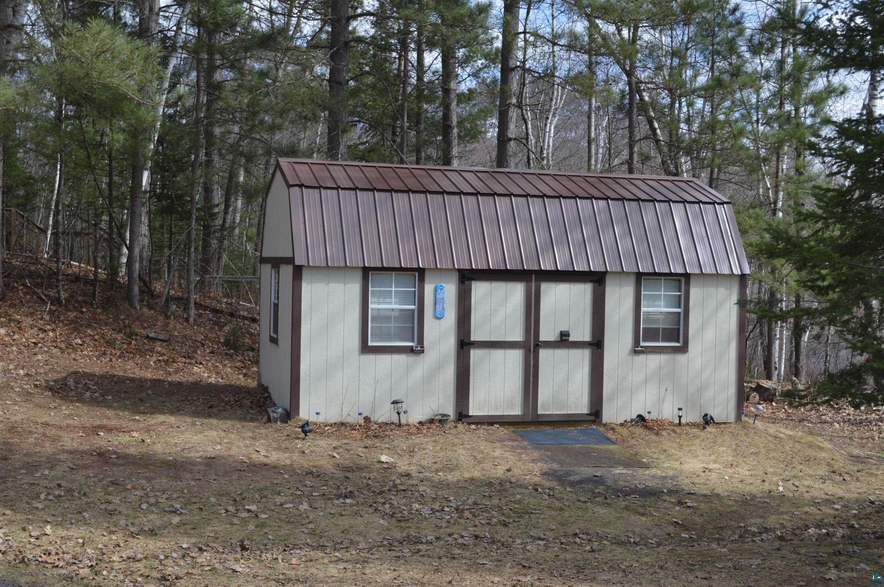 8467 County Rd P Lake Nebagamon, WI 54849 - Photo 17 of 25 Gable-roofed storage shed featuring a metal roof, double entry doors, and two windows