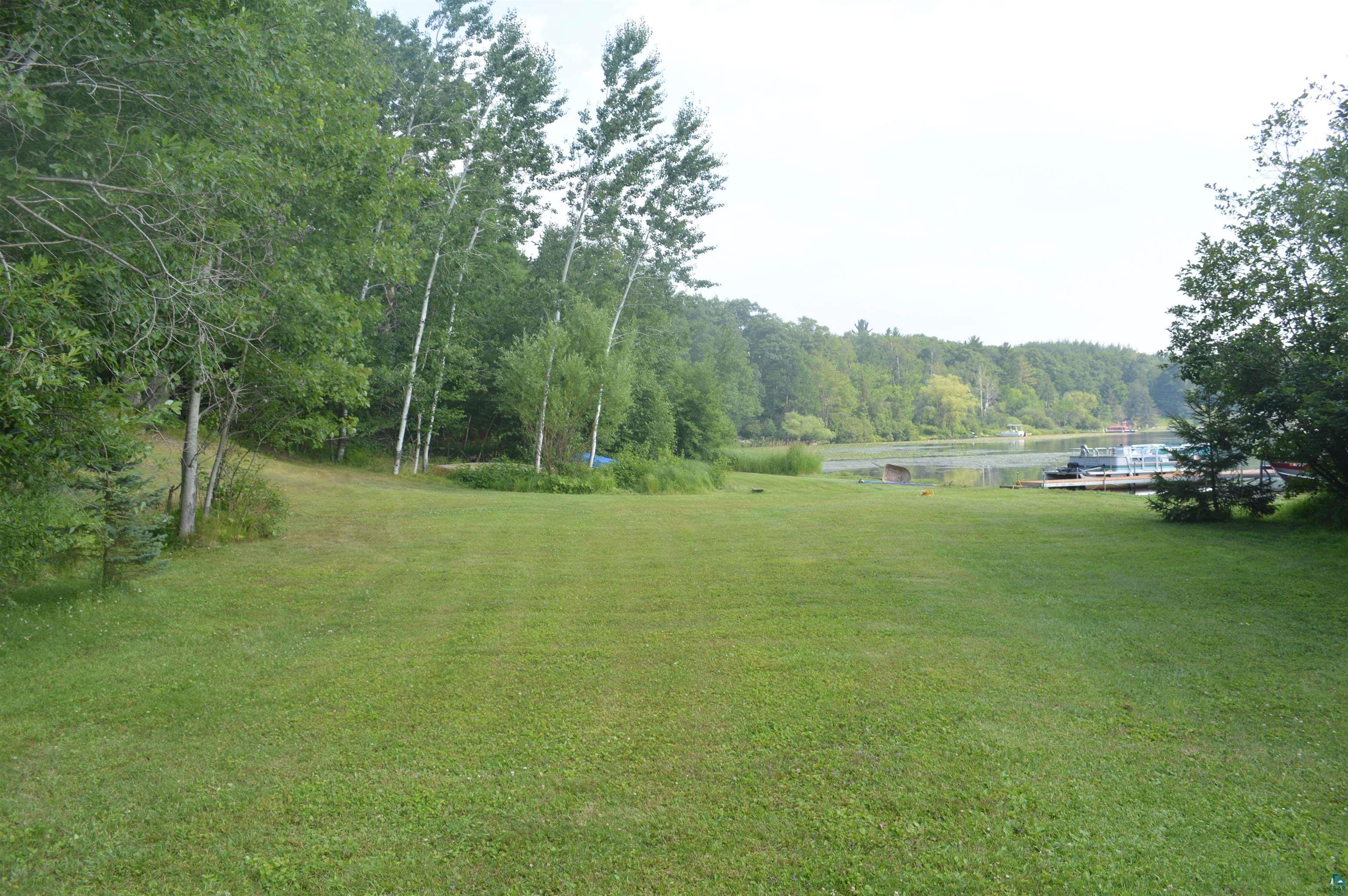 8467 County Rd P Lake Nebagamon, WI 54849 - Photo 19 of 25 Expansive green lawn with mature trees and waterfront access