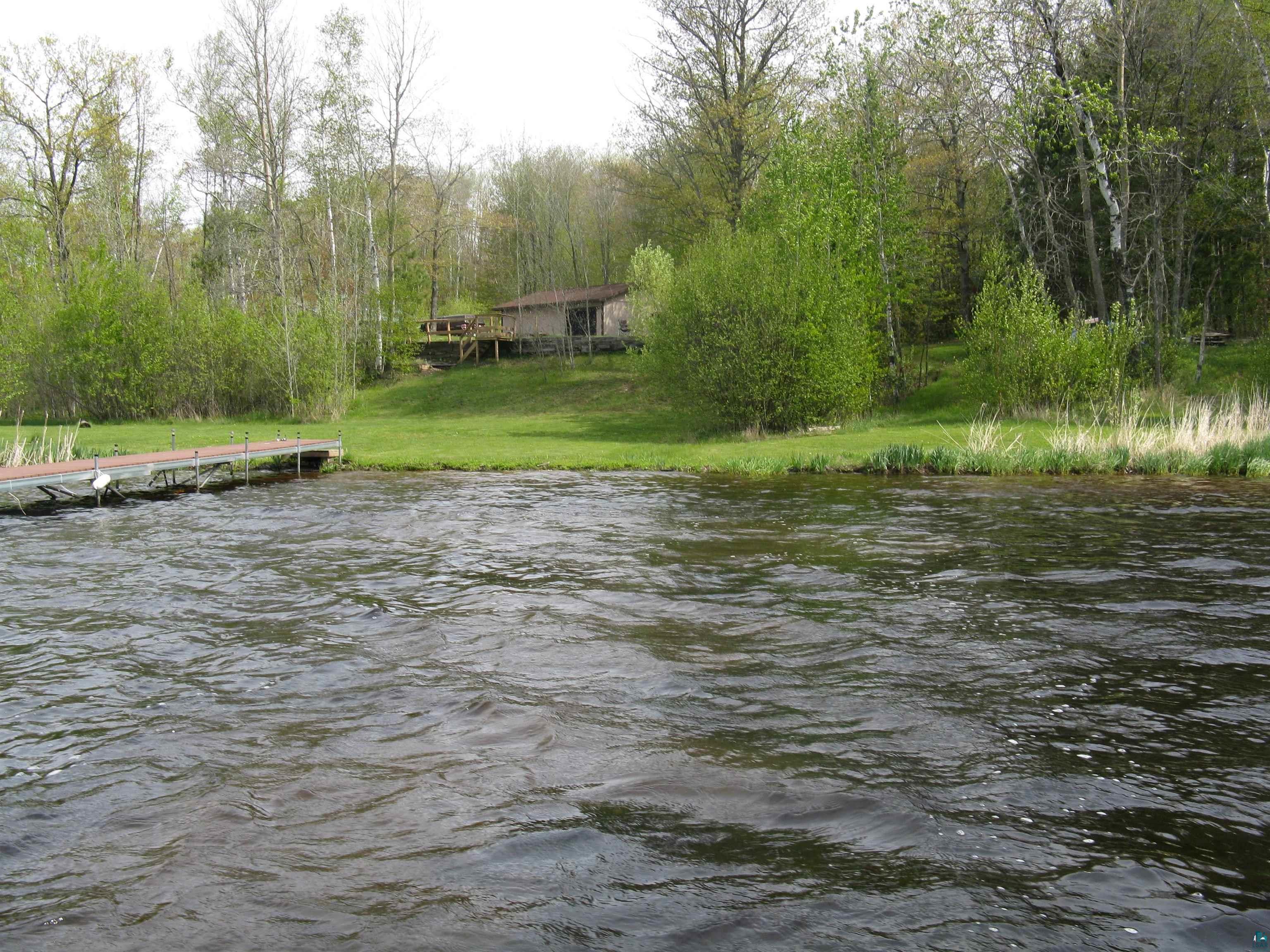 8467 County Rd P Lake Nebagamon, WI 54849 - Photo 22 of 25 Waterfront property with a private dock, green lawn, and mature trees