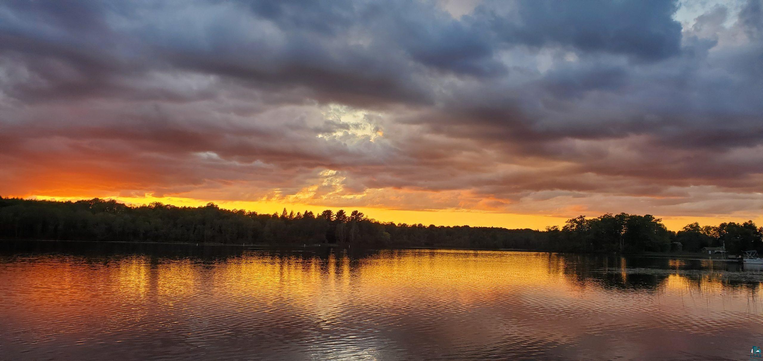 8467 County Rd P Lake Nebagamon, WI 54849 - Photo 24 of 25 Tranquil water setting with a vibrant sunset backdrop, featuring natural tree lines and reflected sky colors
