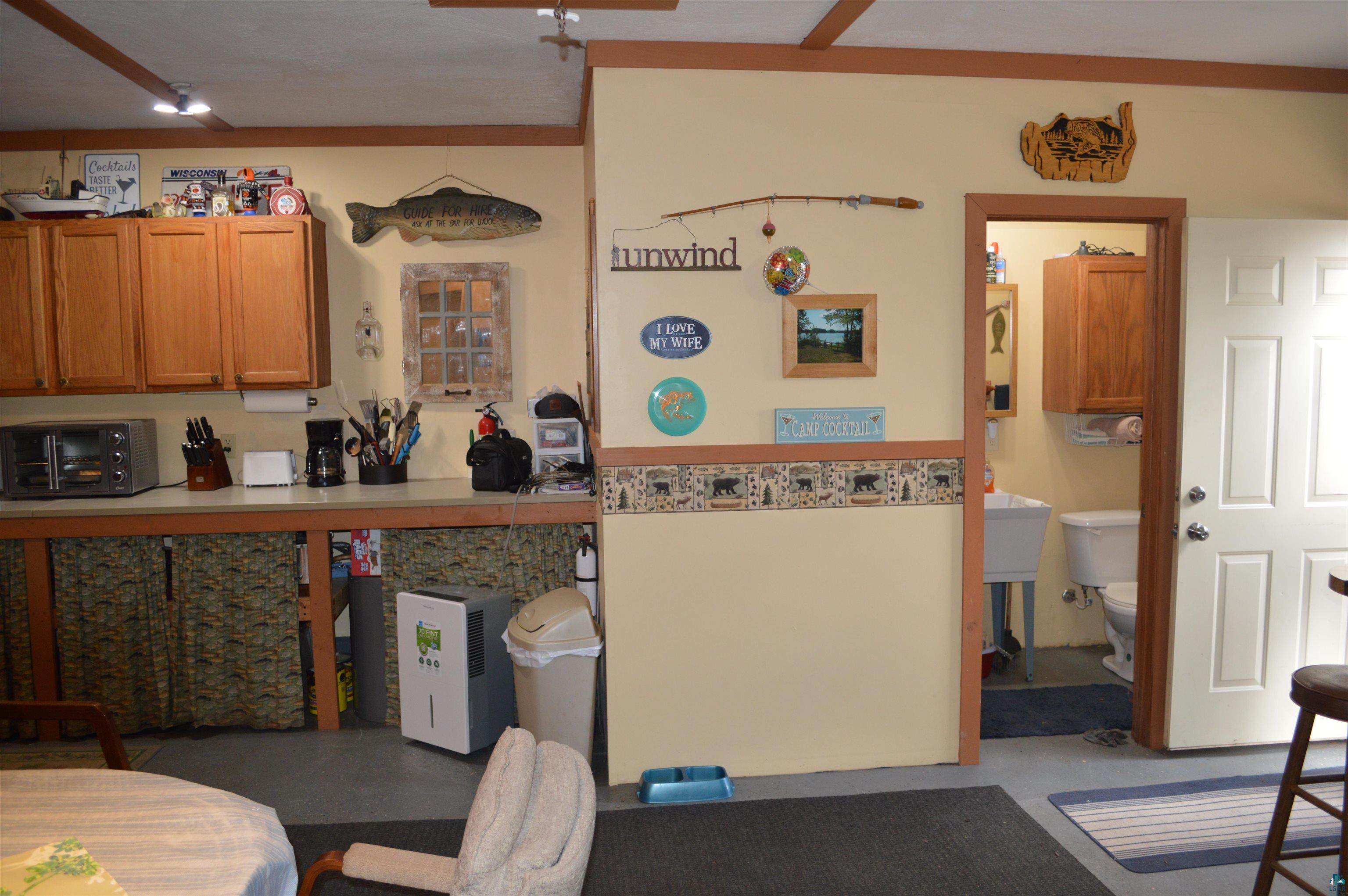 8467 County Rd P Lake Nebagamon, WI 54849 - Photo 7 of 25 Kitchen area with wood-finish upper cabinetry and a light-toned countertop