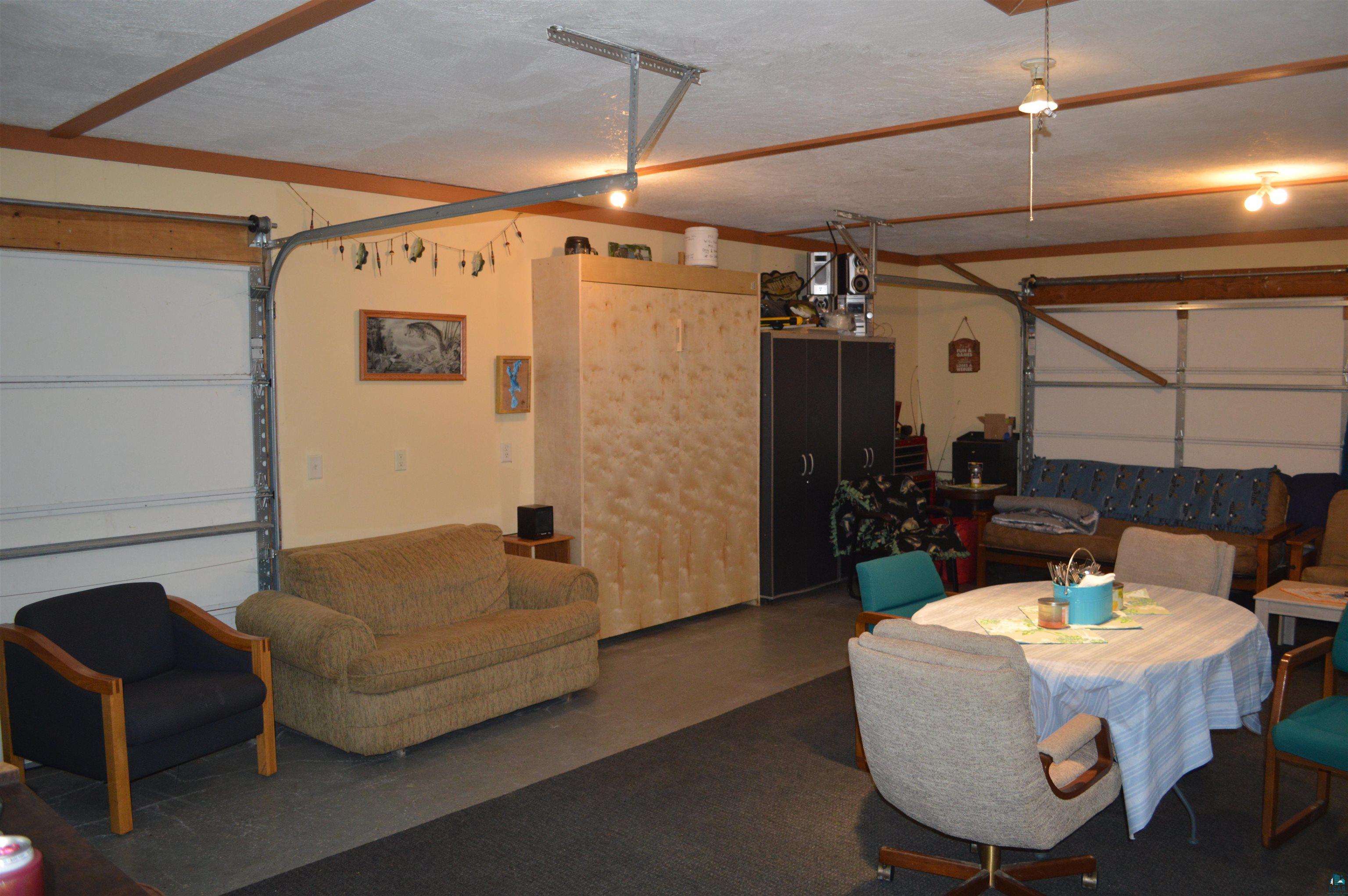 8467 County Rd P Lake Nebagamon, WI 54849 - Photo 8 of 25 Garage interior with light-colored walls and exposed wood ceiling beams
