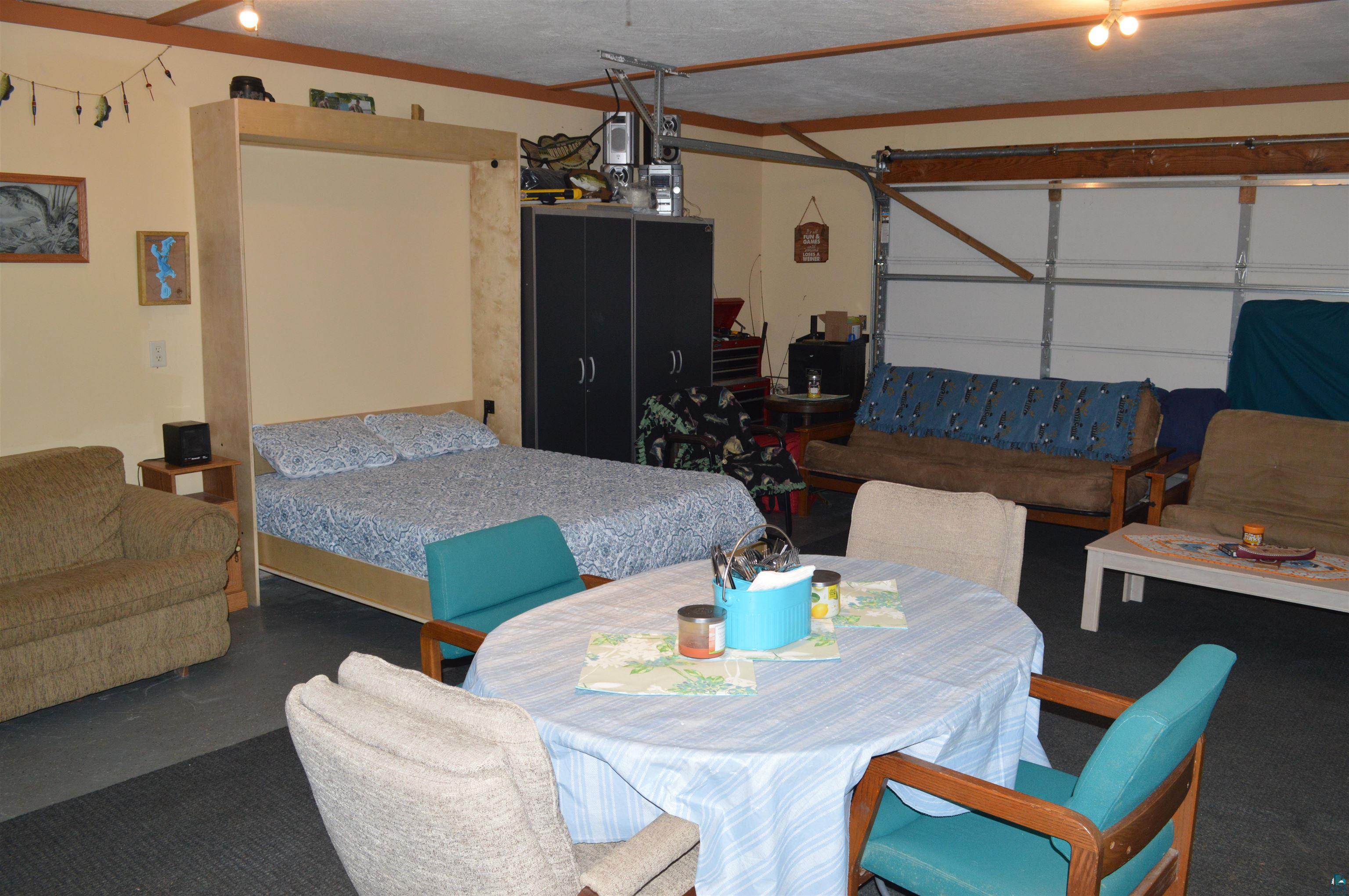 8467 County Rd P Lake Nebagamon, WI 54849 - Photo 9 of 25 Versatile bonus space featuring a built-in wall bed, overhead lighting, garage door access, and exposed ceiling beams