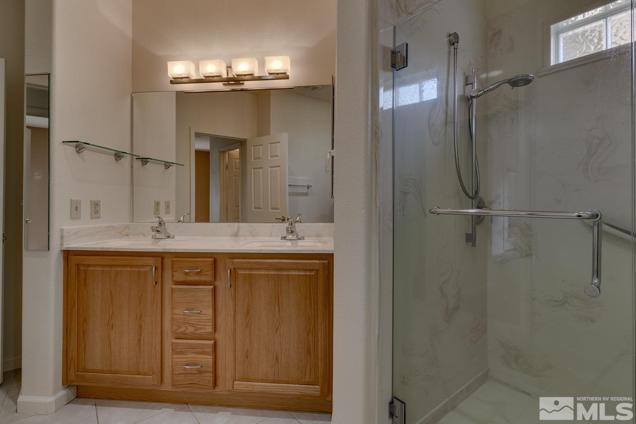 900 S Meadows, Unit 2623 Reno, NV 89521 - Photo 17 of 28 a bathroom with a granite countertop sink a mirror and a shower