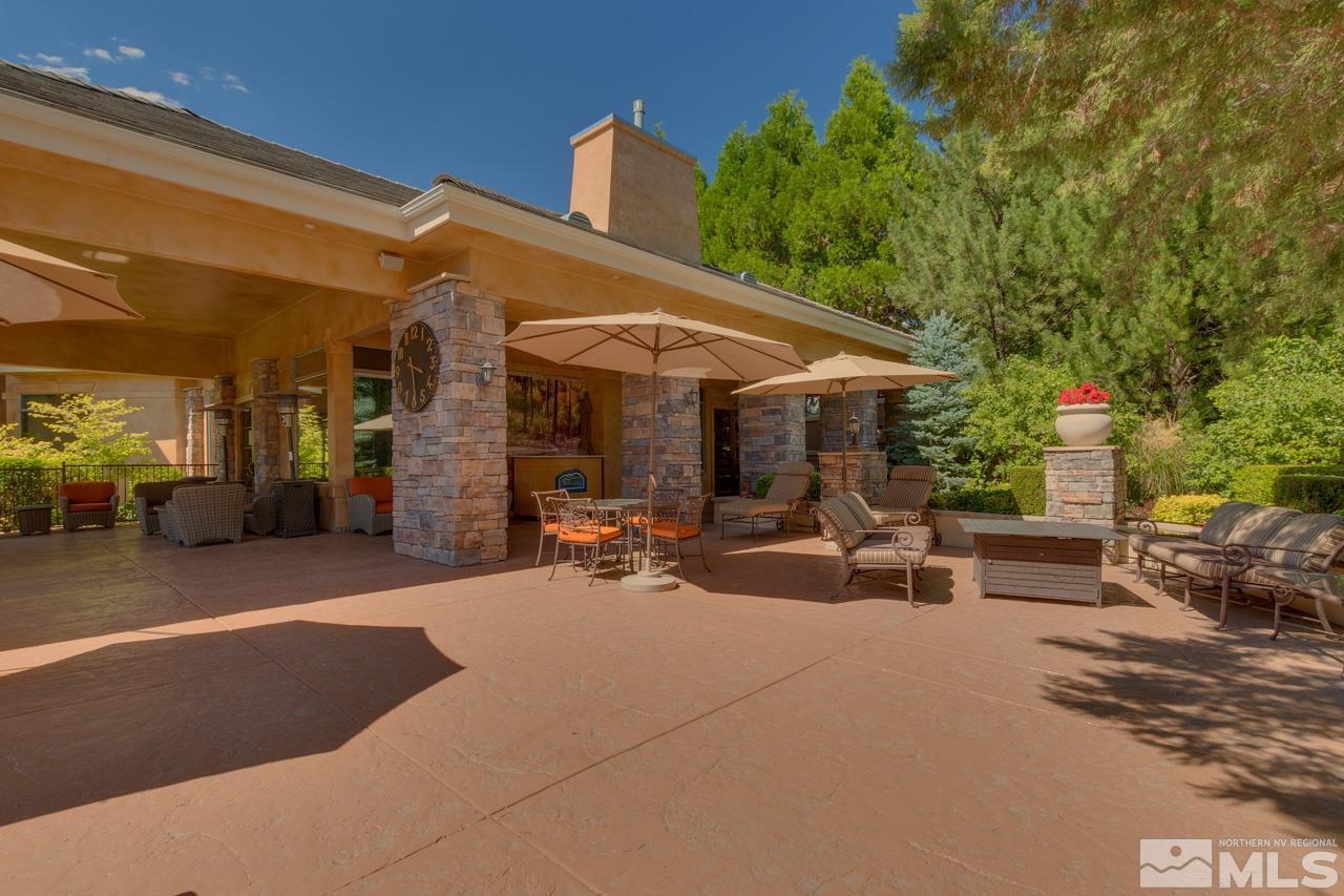 900 S Meadows, Unit 2623 Reno, NV 89521 - Photo 26 of 28 a view of a patio with table and chairs under an umbrella with a barbeque