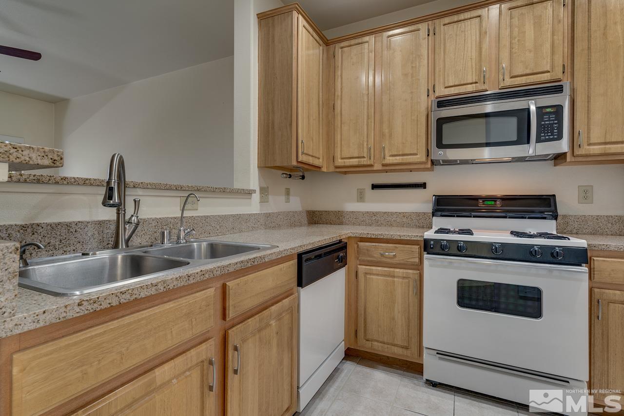 900 S Meadows, Unit 2623 Reno, NV 89521 - Photo 5 of 28 a kitchen with granite countertop white cabinets stainless steel appliances and a sink