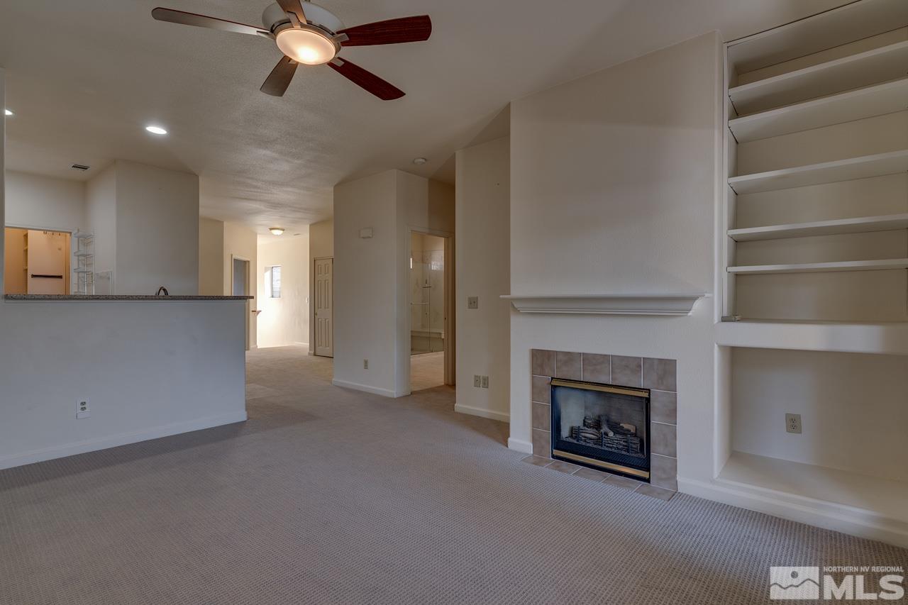 900 S Meadows, Unit 2623 Reno, NV 89521 - Photo 9 of 28 a view of a kitchen and an empty room with a fireplace