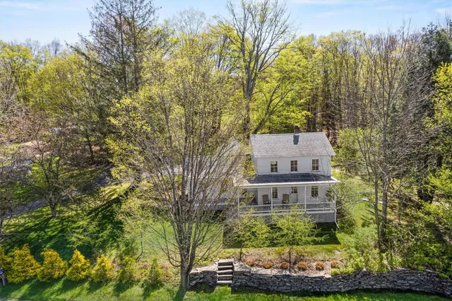 a view of a house with a yard and large trees
