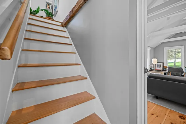 a view of a bedroom with a bed and wooden floor