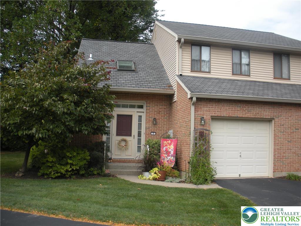 a front view of a house with a garden and plants
